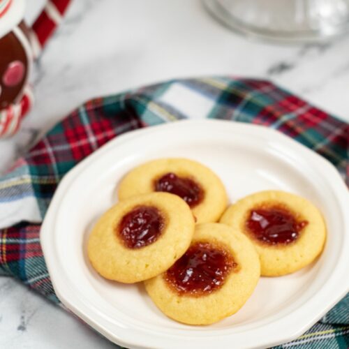 A white plate of strawberry jam cookies.