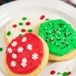 soft frosted sugar cookies on a white plate.