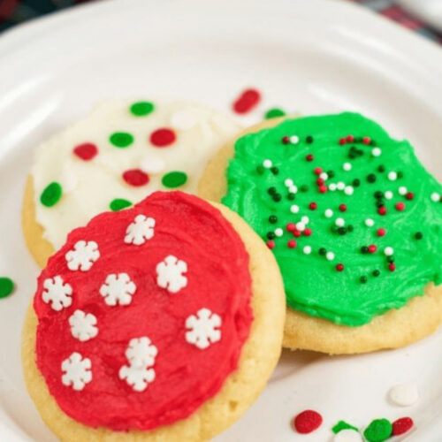 soft frosted sugar cookies on a white plate.