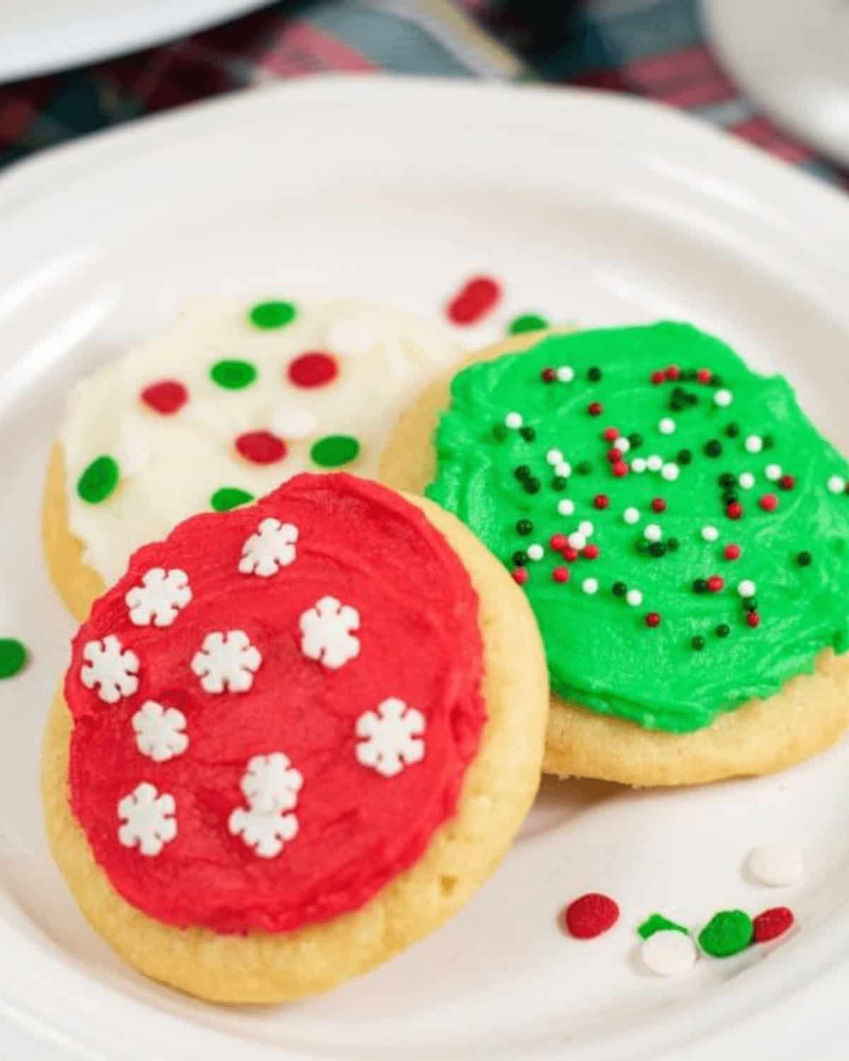 soft frosted sugar cookies on a white plate.