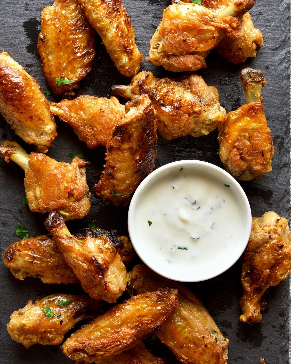 Wings with dipping sauce on a platter.
