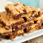 A stack of cookie bars on a square white plate.