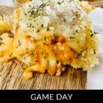 Close-up of Italian meatball sliders topped with cheese and herbs on a rustic wooden surface, perfectly capturing the essence of "Game Day Meatball Sliders.