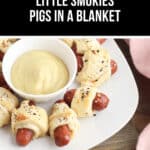 A delightful plate of Little Smokies Pigs in a Blanket surrounds a bowl of tangy yellow dipping sauce, inviting you to dip and savor every delicious bite.