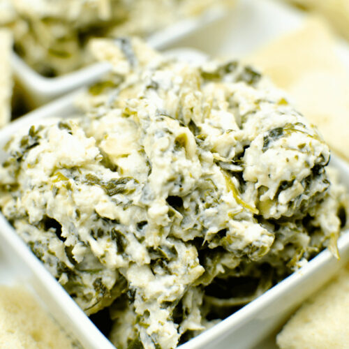 Olive Garden spinach dip with crackers on a white plate.