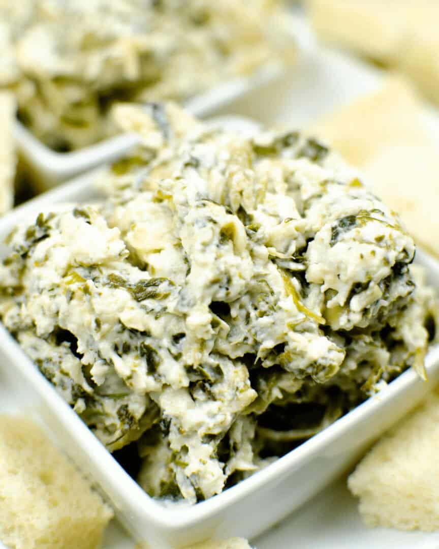 Olive Garden spinach dip with crackers on a white plate.