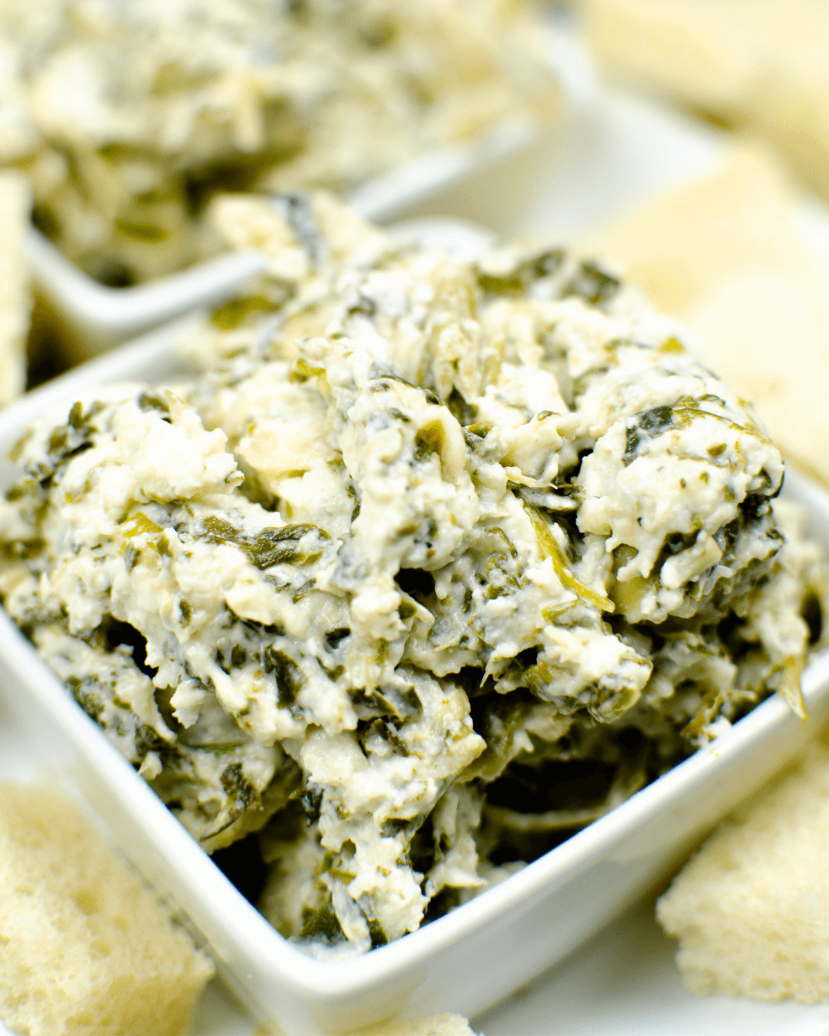 Olive Garden spinach dip with crackers on a white plate.