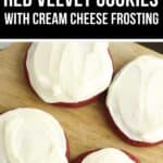 Four Red Velvet Cookies with Cream Cheese Frosting are beautifully displayed on a wooden surface.