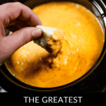 A person dunks bread into a luscious, orange delight simmering in a slow cooker. Text reads: "The Ultimate Slow Cooker Pizza Dip Experience.