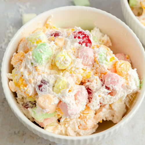 A white dish of Ambrosia Salad with Cool Whip.