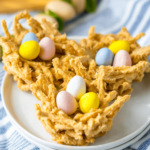 A homemade Easter-themed bird’s nest cookies with pastel-colored candy eggs on a white plate.
