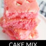 Three pink Cake Mix Strawberry Brownies with white chocolate chips are stacked on a plate; text overlay reads "Cake Mix Strawberry Brownies.