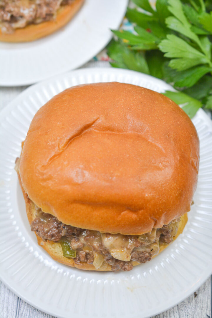 A close up on the cheese steak sloppy joe with greens on the side.