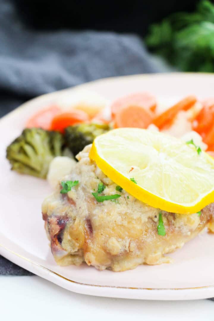A side view of the lemon chicken with a slice of lemon on top.