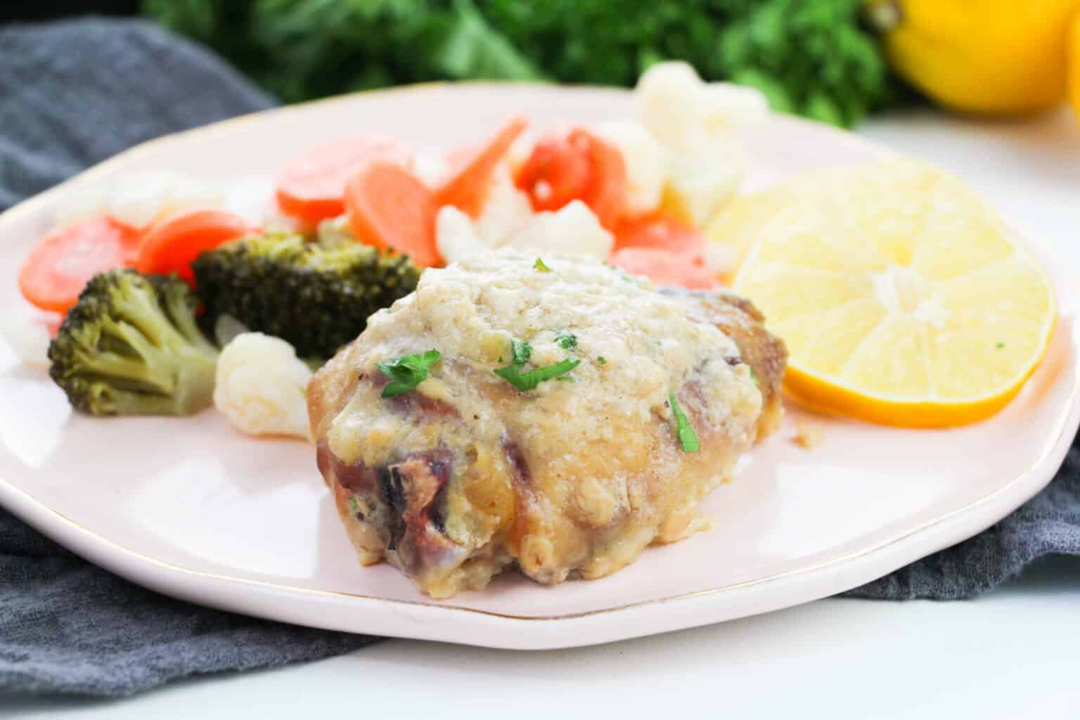 A white plate of the chicken and vegetables.