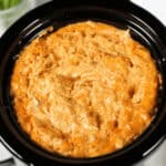 Savor the irresistible allure of this creamy Crock Pot Buffalo Chicken Dip, served in a sleek black crockpot.