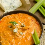 Healthy Buffalo Chicken Dip with celery in the dip.
