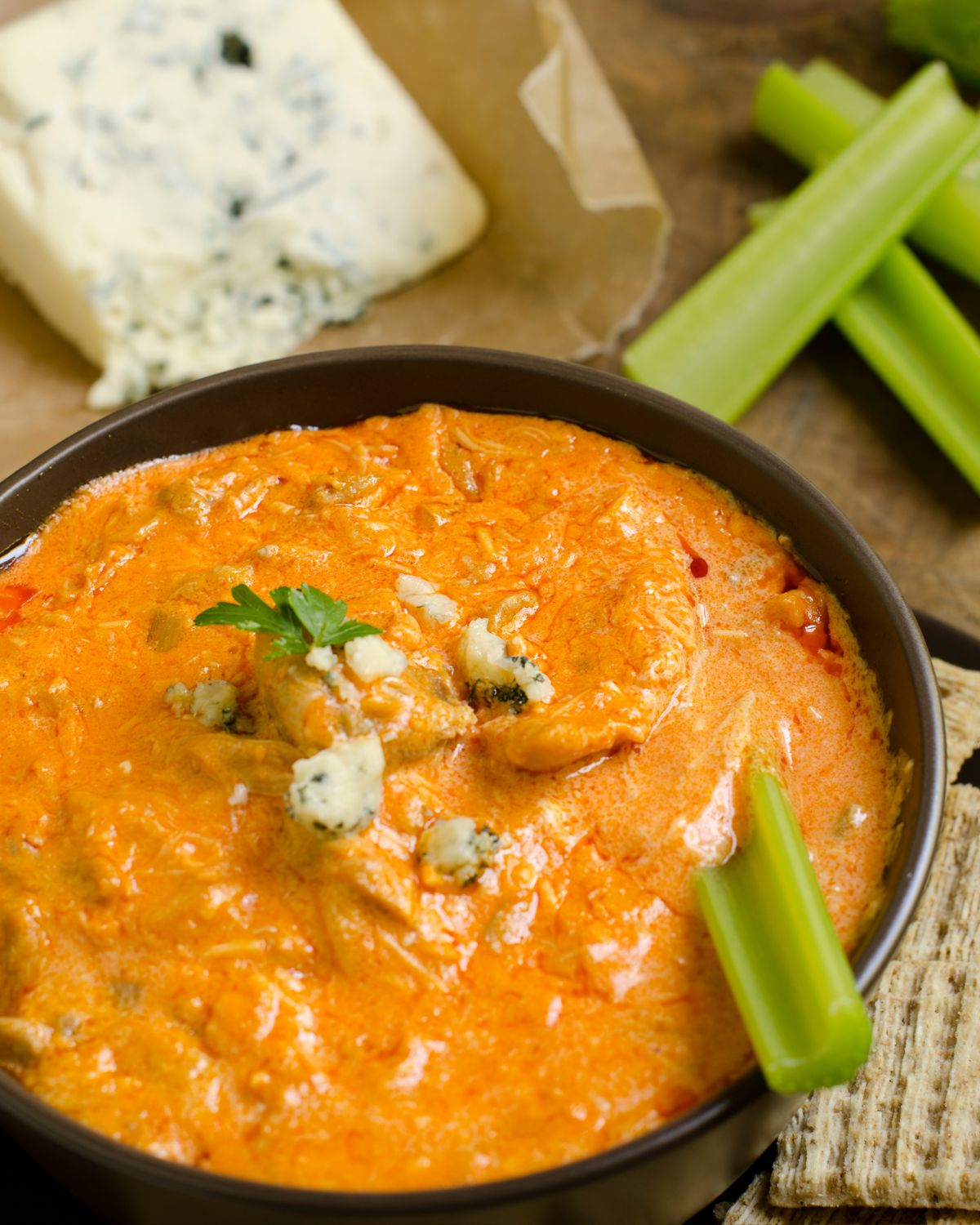 Healthy Buffalo Chicken Dip with celery in the dip.