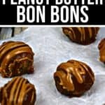 Five Peanut Butter Bon Bons, chocolate-coated and drizzled with peanut butter, sit on white parchment paper atop a wooden surface.