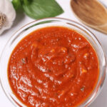 A bowl of freshly made San Marzano pizza sauce with herbs and garlic.