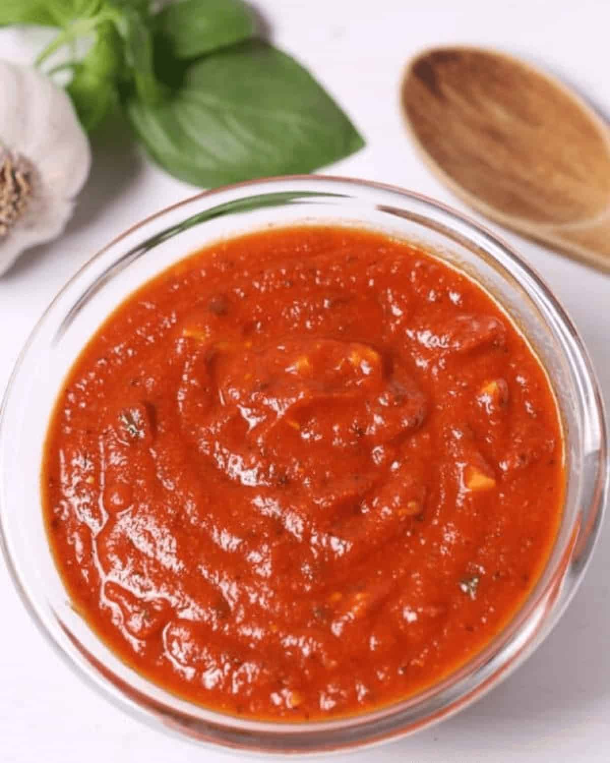 A bowl of freshly made San Marzano pizza sauce with herbs and garlic.