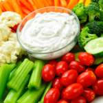 A plate of vegetables with Sour Cream and Ranch Dip.