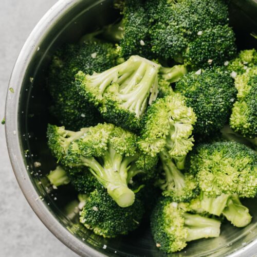A bowl of cooked broccoli.