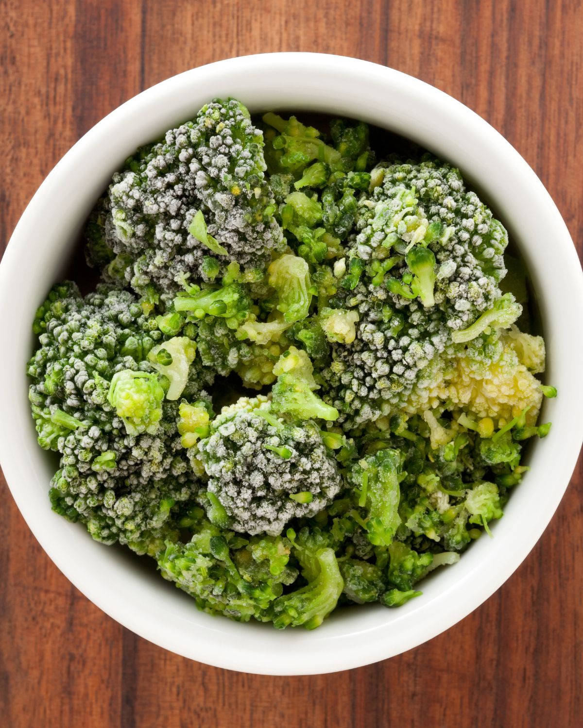 A white dish of frozen fresh broccoli.