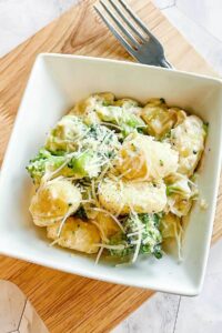 The pasta in the sauce with parmesan on top.