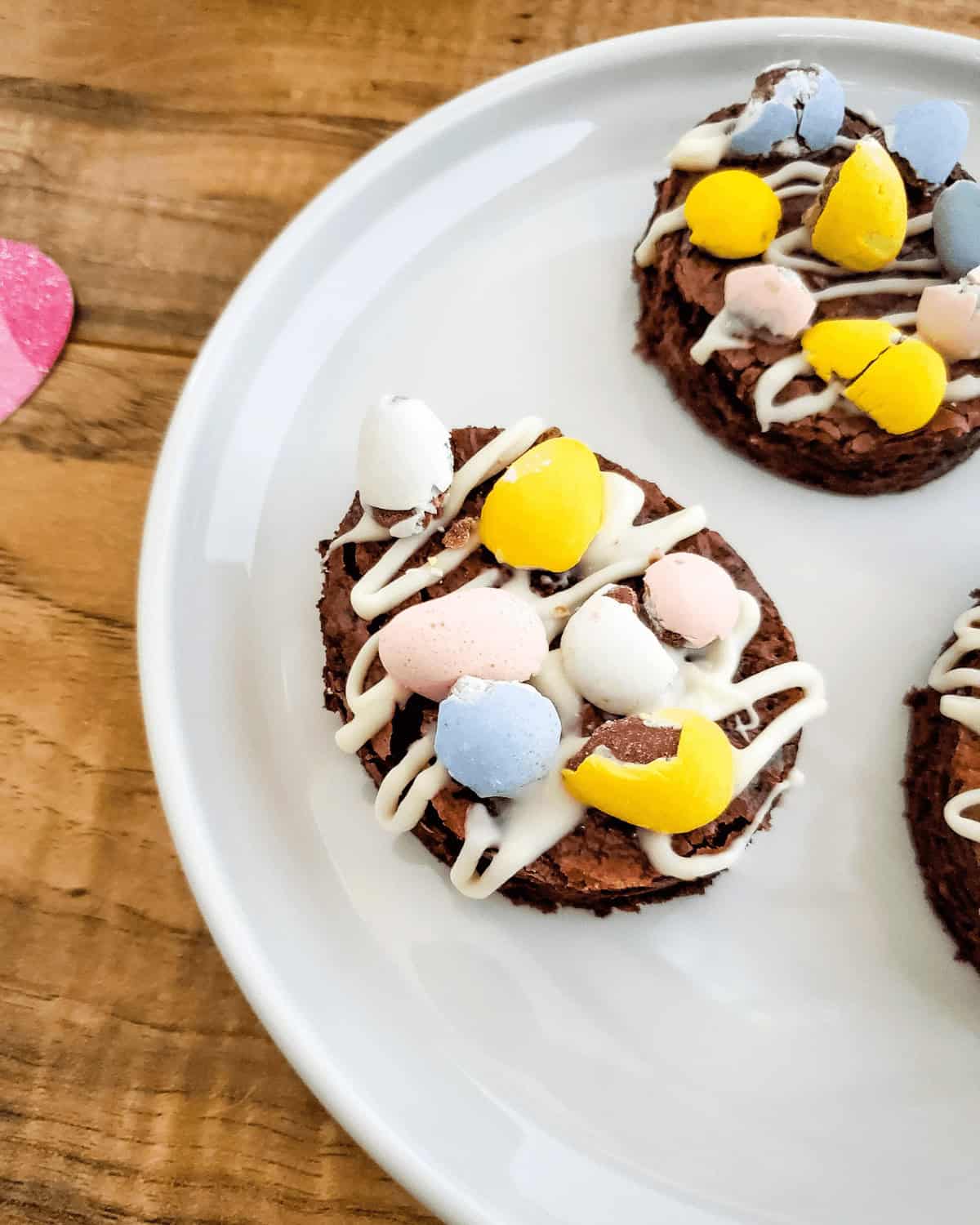A dessert topped with pastel-colored candies and white icing on a white plate.