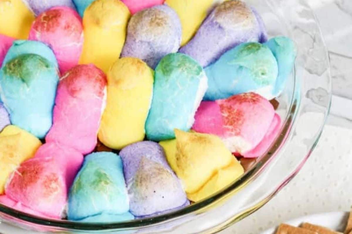 A glass bowl brimming with marshmallow Peeps in pastel hues of pink, yellow, blue, and purple makes delightful Easter treats for kids.