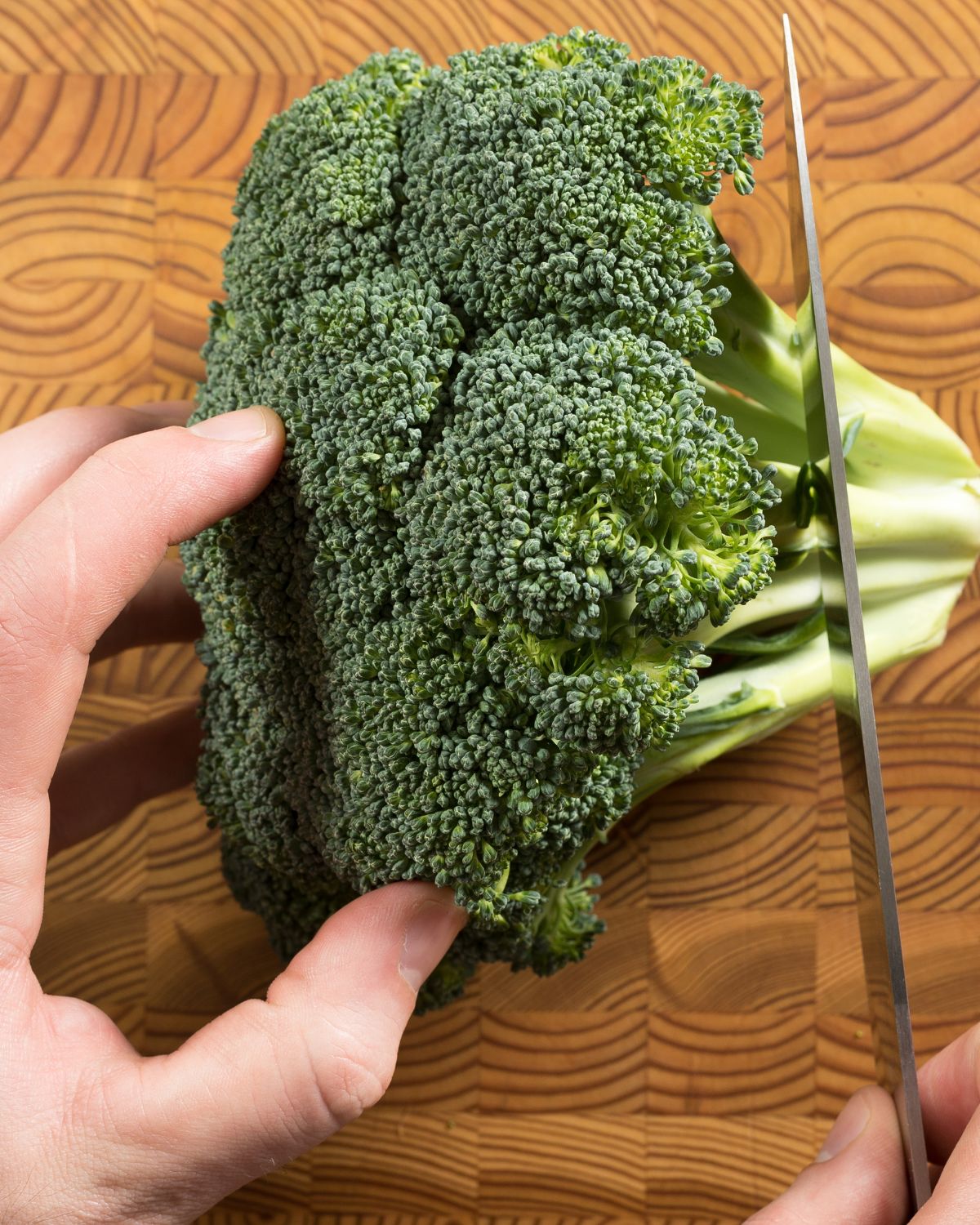 Chopping off the stem of the broccoli.