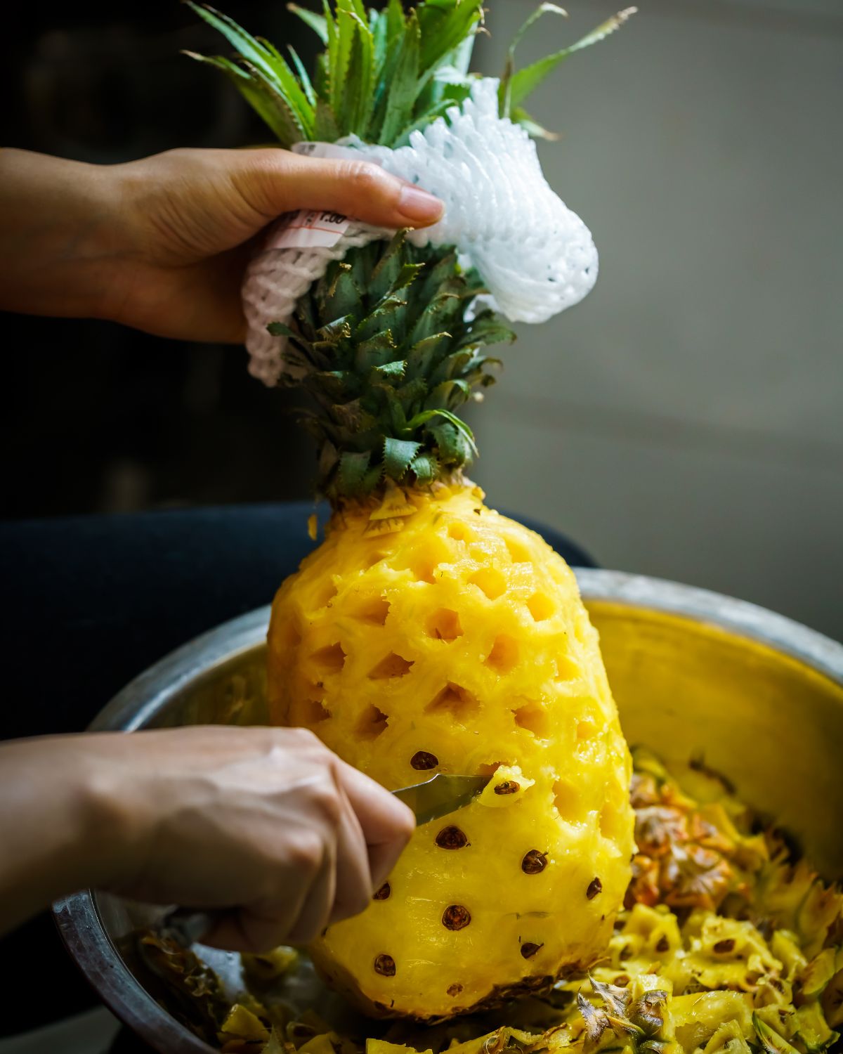Cutting the pineapple skin.