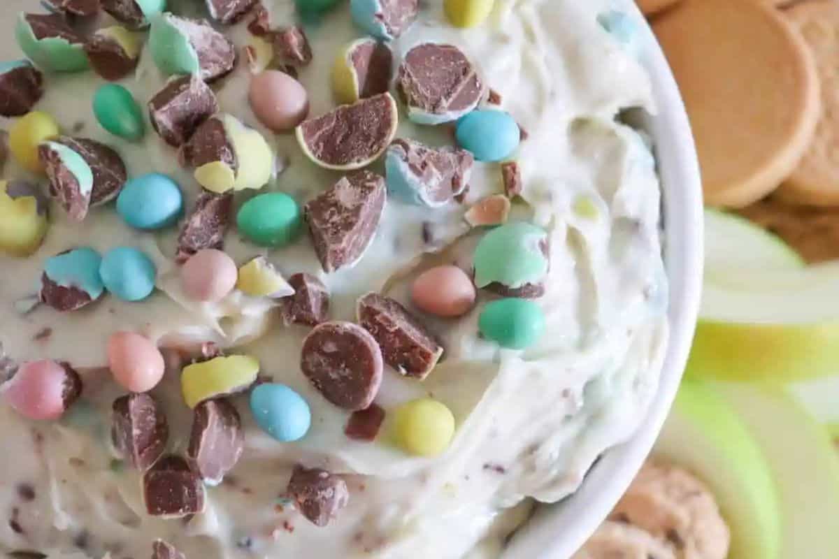 A bowl of creamy dip topped with colorful candy-coated chocolate pieces makes the perfect Easter treat for kids.