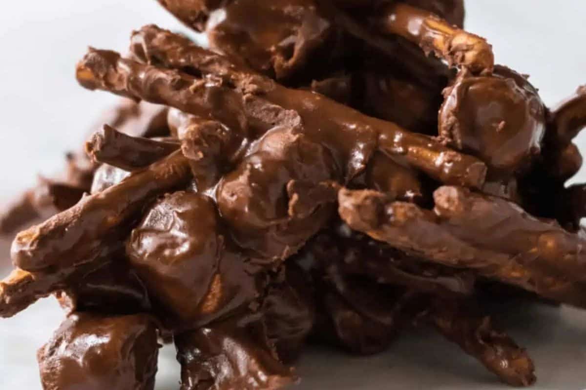 A delightful pile of chocolate and peanut butter-coated pretzels and nuts sits on a light surface, perfect as Easter treats for kids.