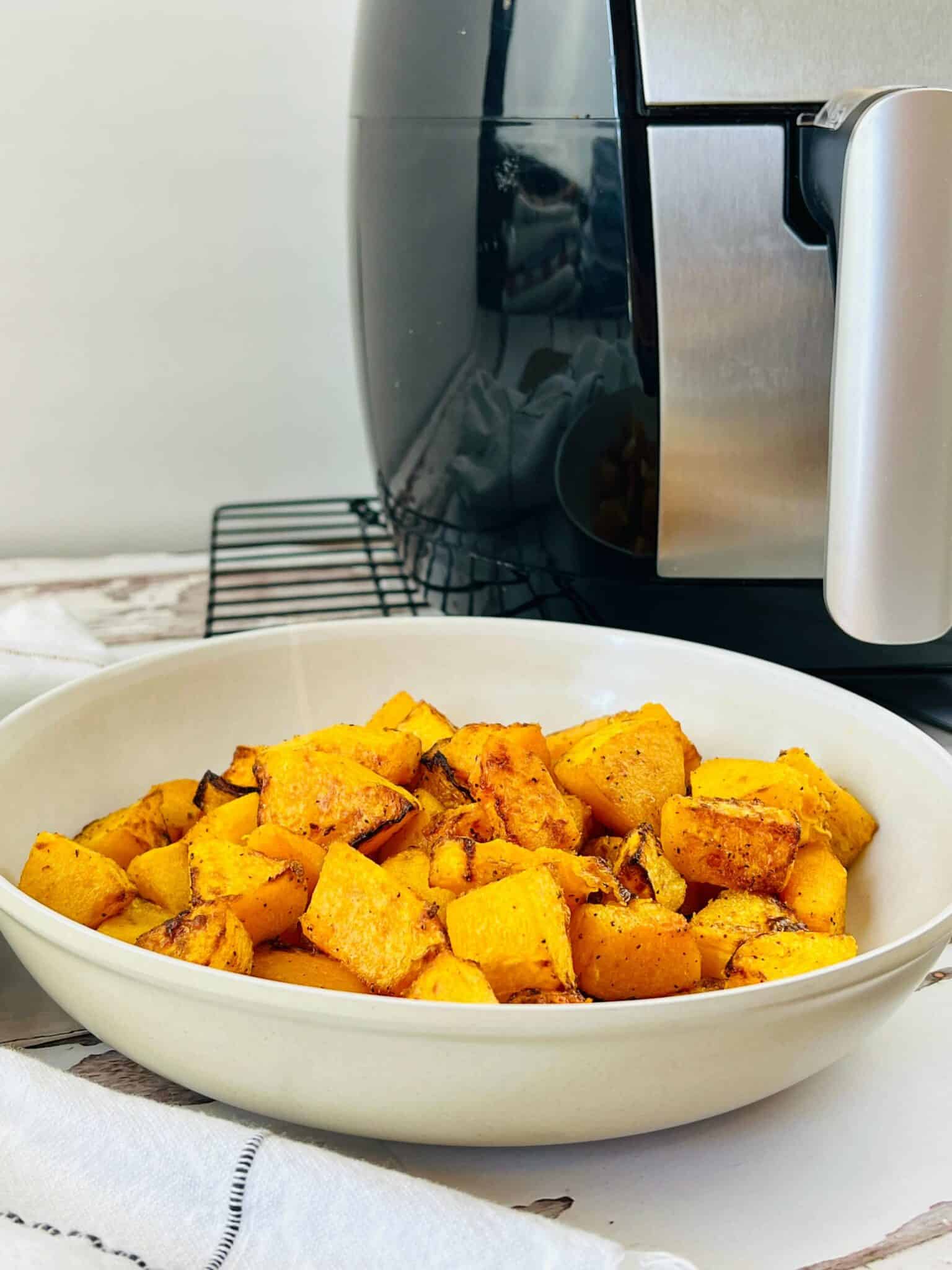 A white bowl of air fryer butternut squash.