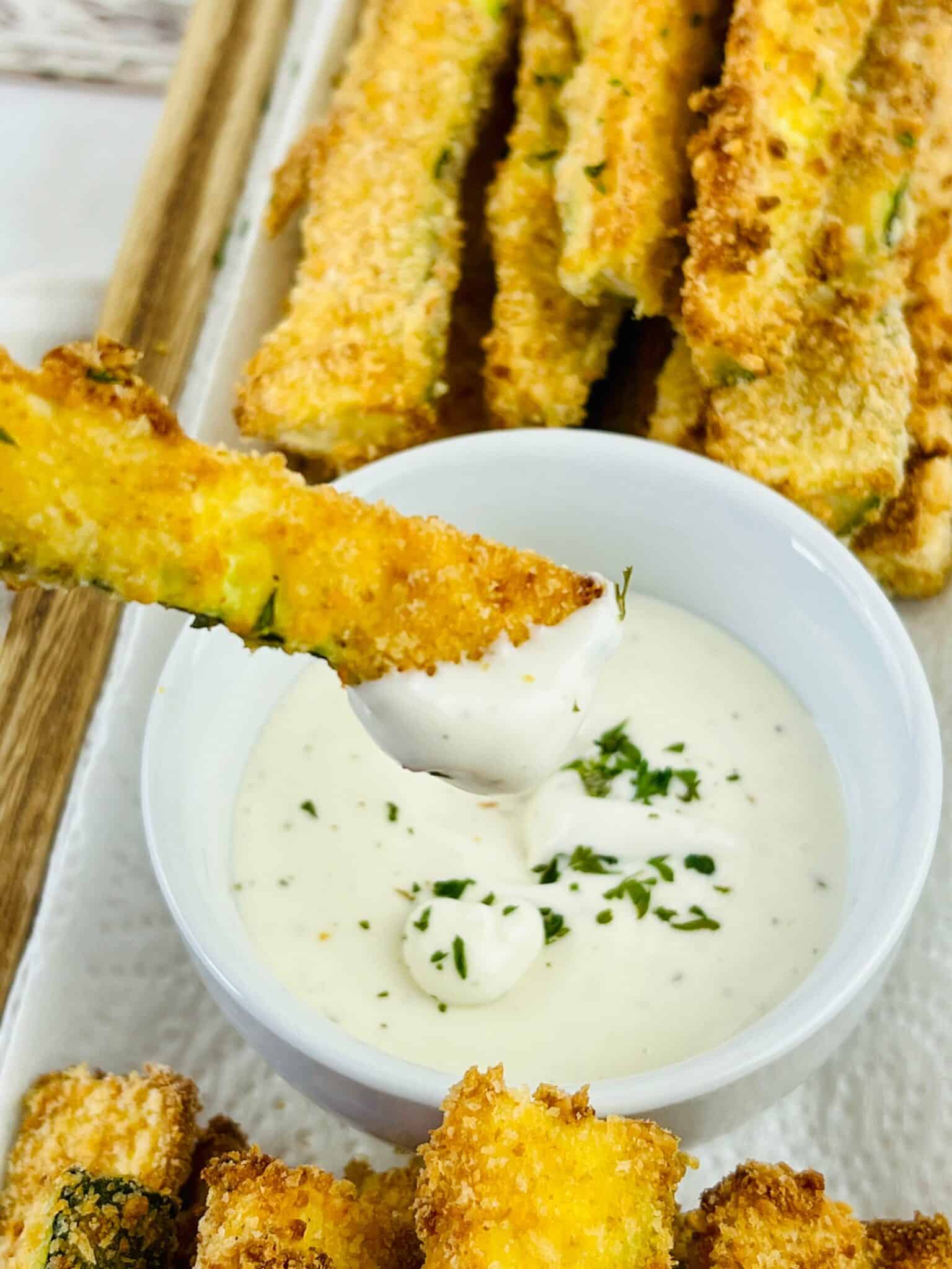 Dipping an oven baked zucchini fry in sauce.
