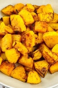 Bowl of roasted Air Fryer Butternut Squash cubes with a golden-brown, slightly charred exterior, seasoned with spices.