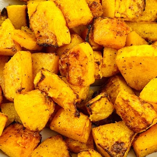 Bowl of roasted Air Fryer Butternut Squash cubes with a golden-brown, slightly charred exterior, seasoned with spices.