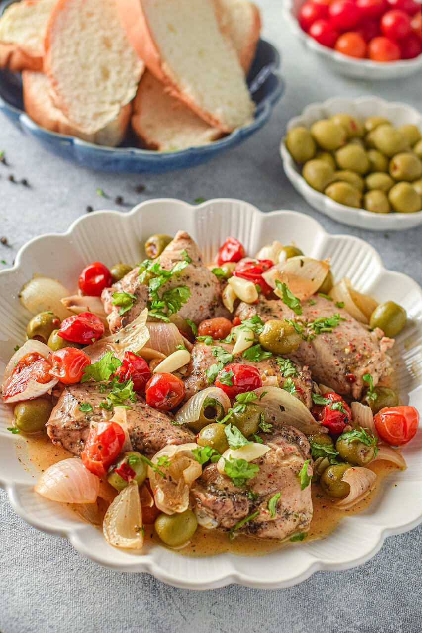 A dish of the chicken provencal with a side of olives.