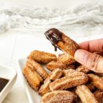 A churro dipped in chocolate sauce.