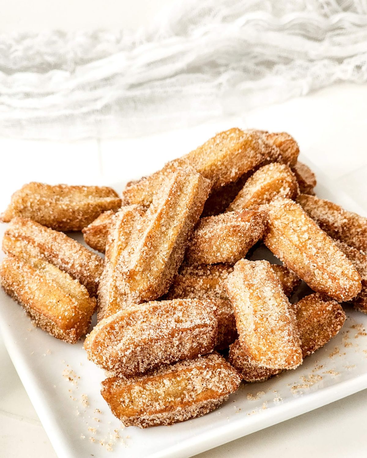 A square white plate of disney churros.