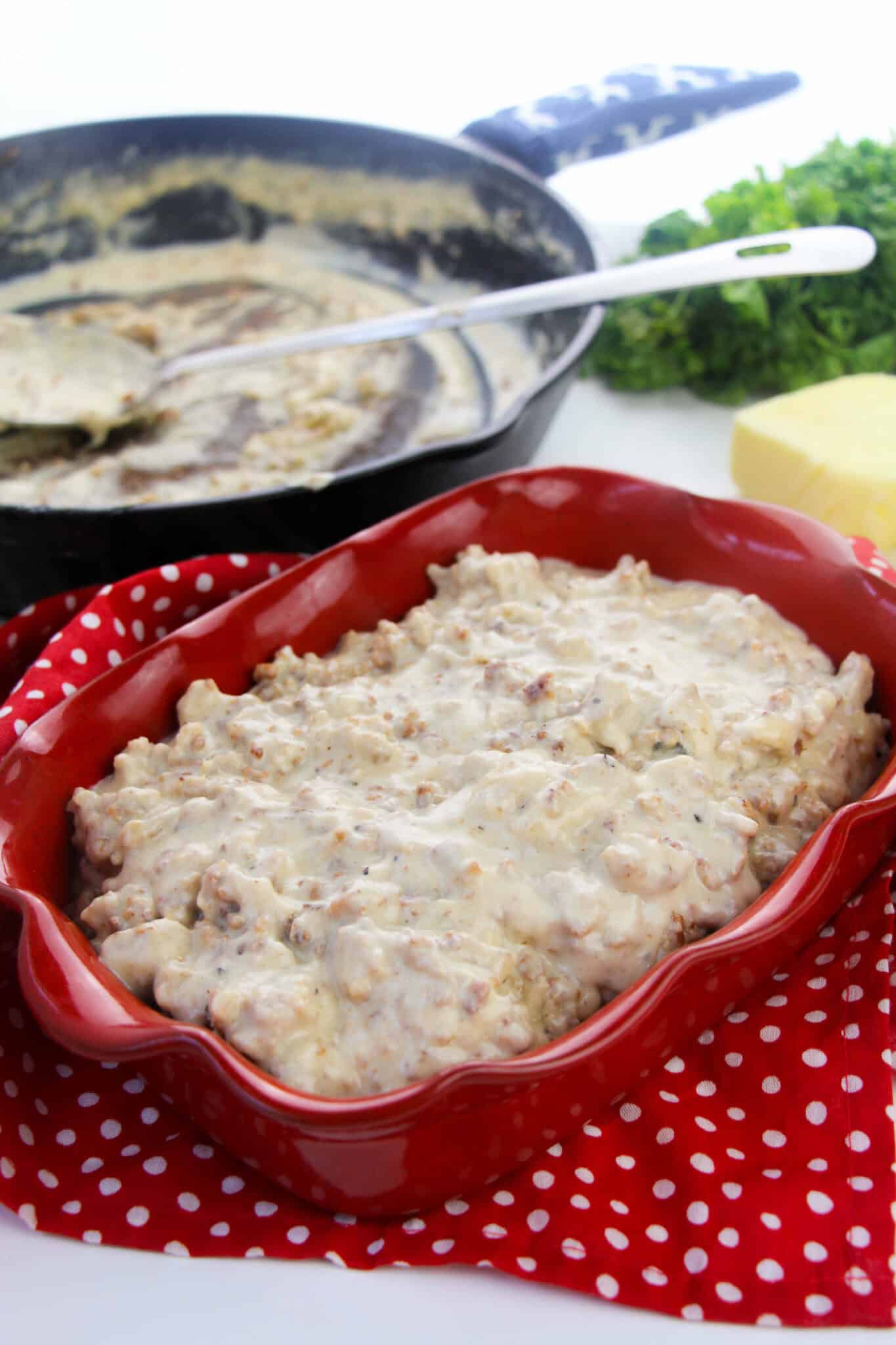 A cast iron pan and a red dish of the completed recipe.