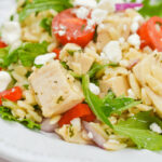 A close up on the orzo chicken salad with tender greens.