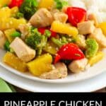 A plate of Pineapple Chicken Stir Fry with broccoli, red bell peppers, and rice is beautifully presented on a white plate.