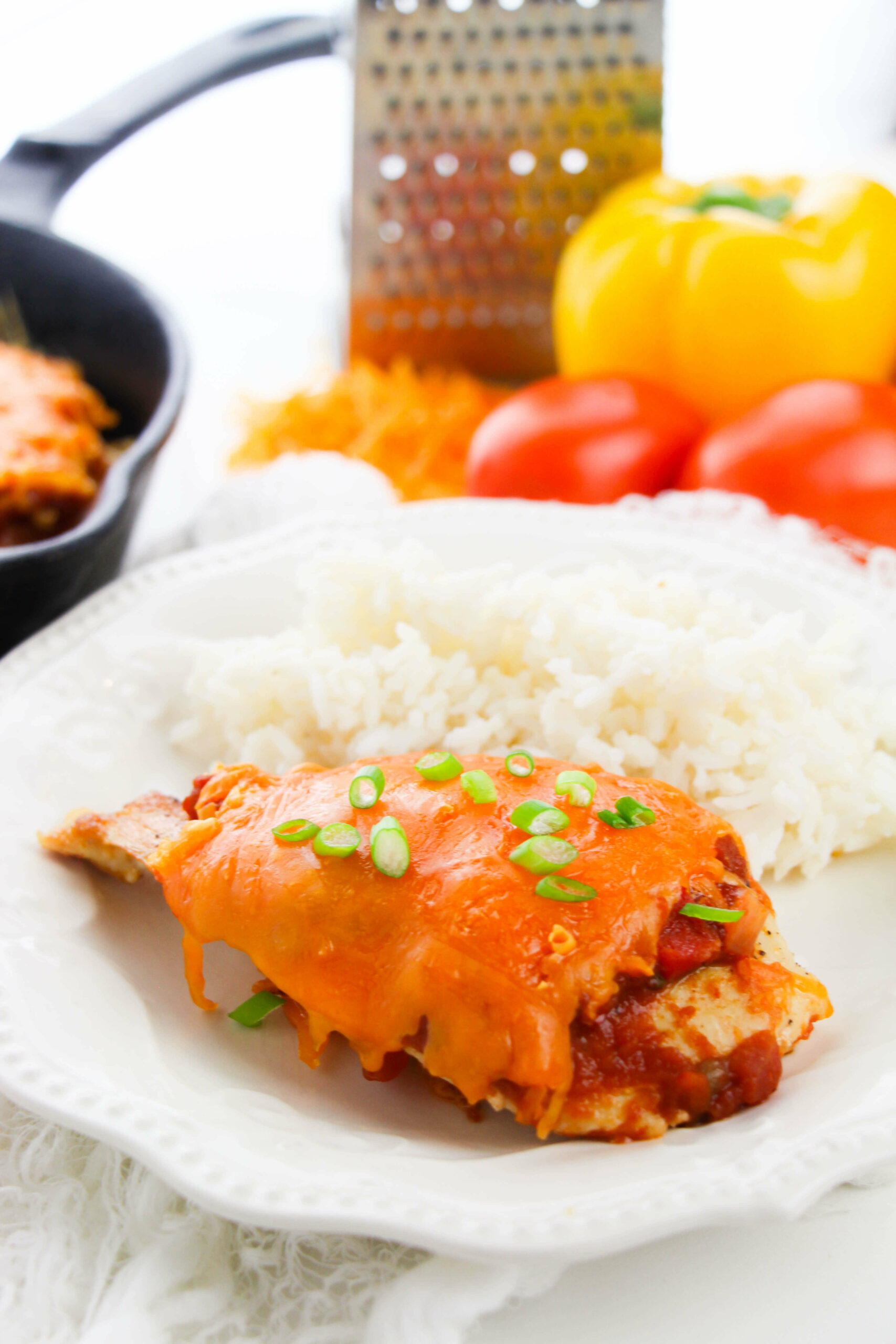 A piece of  salsa chicken with a side of rice.