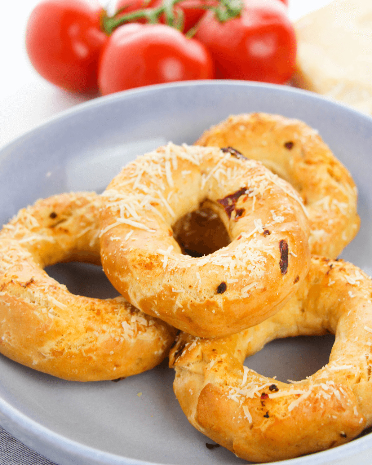 A platter of finished asiago cheese bagels with sundried tomatoes.