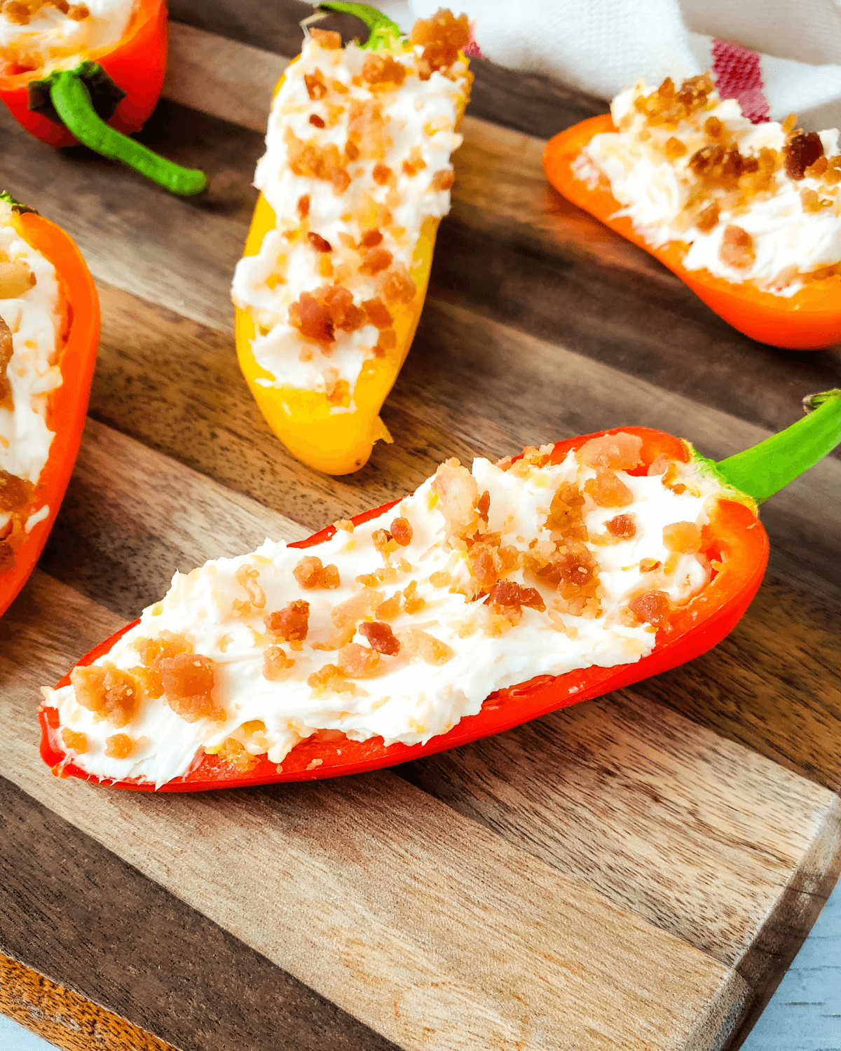 Cheesy Bacon Stuffed mini peppers on a serving board.