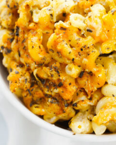 A close-up of cajun mac and cheese in a white bowl.