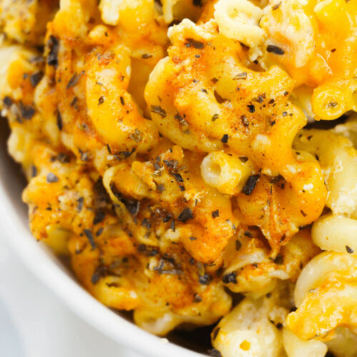 A close-up of cajun mac and cheese in a white bowl.